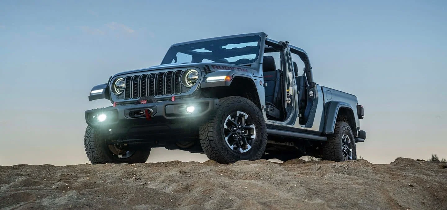 2026 Jeep Gladiator pickup kicking up dust across open desert terrain