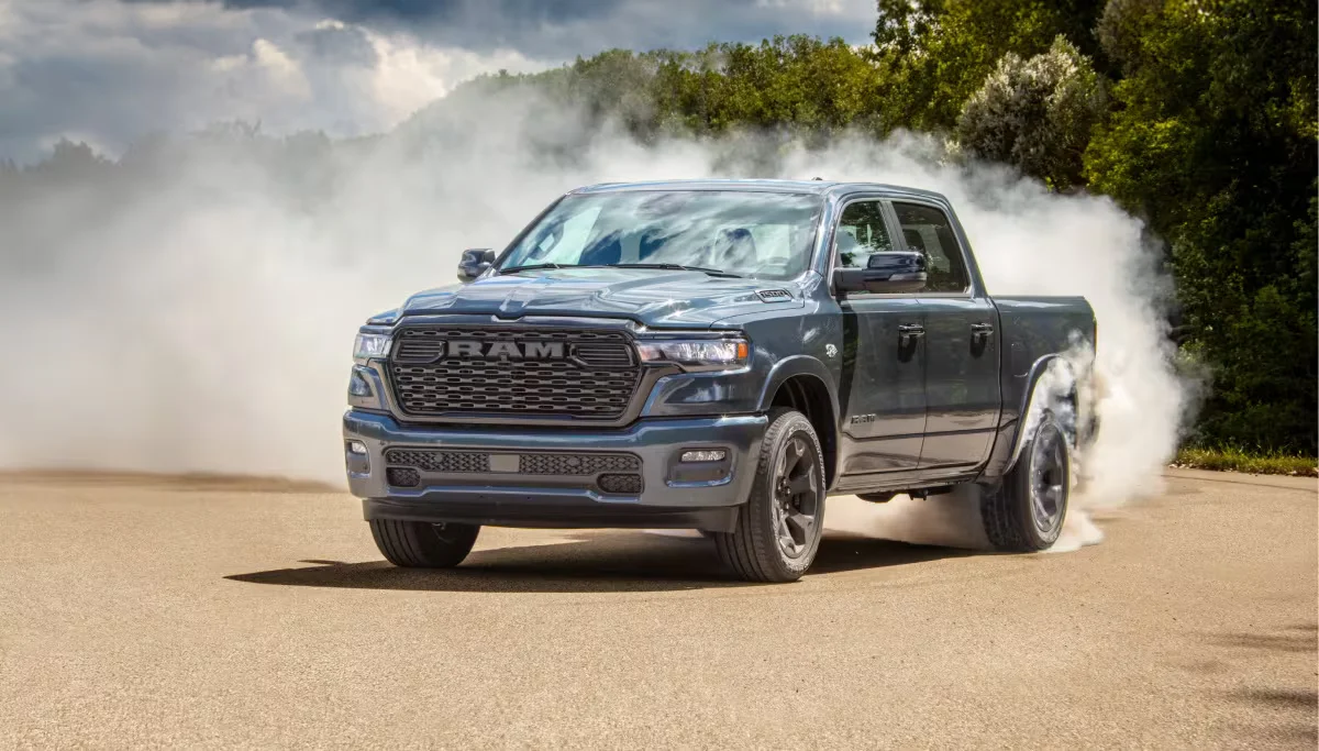 Dark 2026 RAM 1500 driving through a dusty off-road trail toward the camera